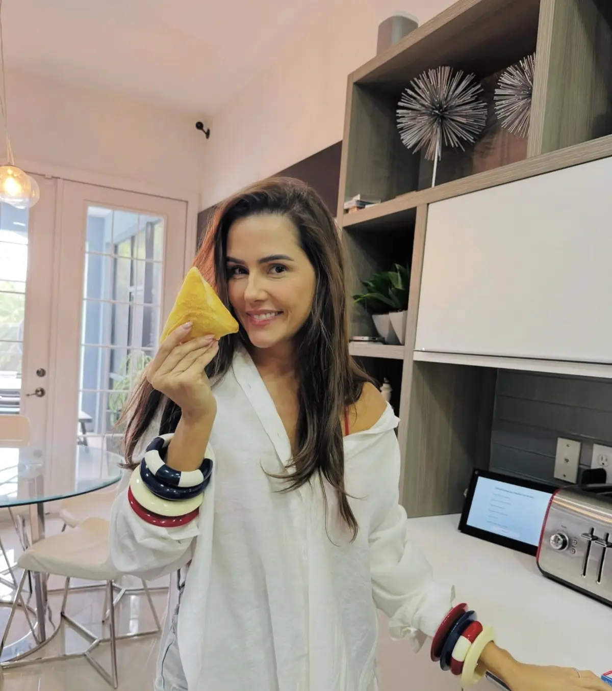 Débora Secco experimentando uma esfiha da Helena’s Gourmet